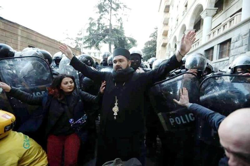 "ნიღბიანები მეუბნებოდნენ: მამაო, ილოცე ჩვენზე, ჩვენი ოჯახის წევრებიც აქ დგანანო" - ვინ არის ბერი, რომელიც აქციაზე სპეცრაზმსა და ხალხს შორის იდგა