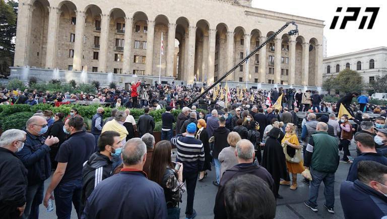 ოპოზიციური პარტიების წევრები და მხარდამჭერები პარლამენტის შენობის წინ აქციას მართავენ