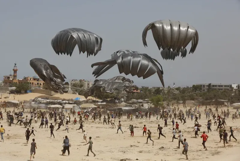 დღის ფოტო: პალესტინელები თვითმფრინავიდან ჩამოყრილი ჰუმანიტარული დახმარების ასაღებად მიიჩქარიან