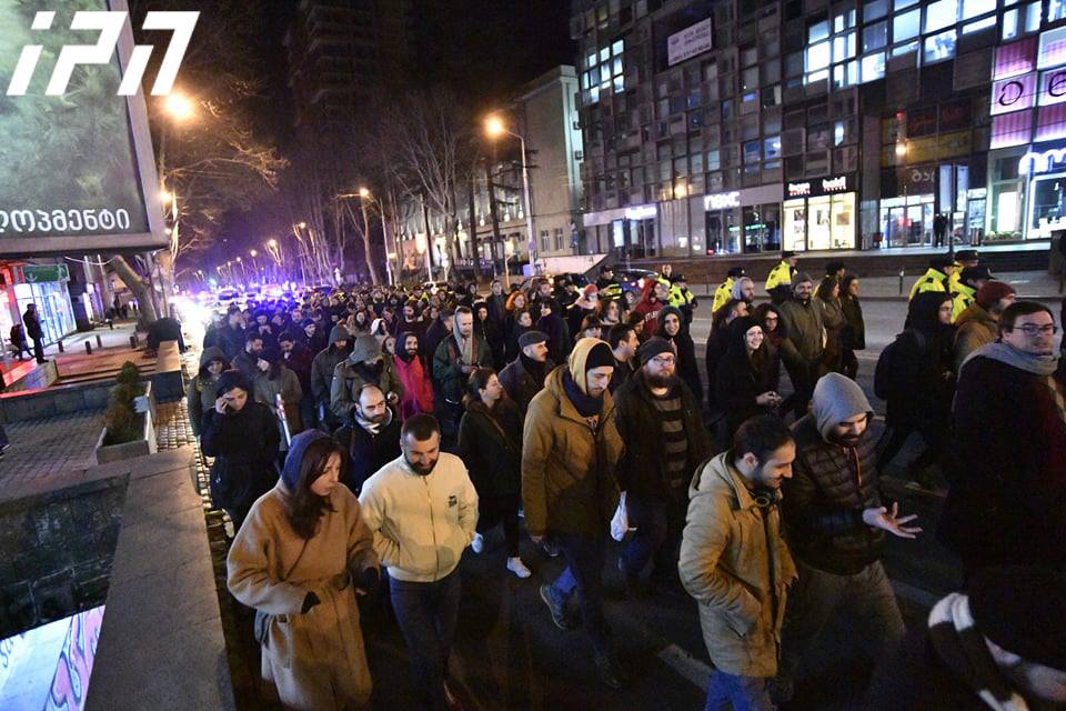 აქციის მონაწილეები კახა კალაძის სახლიდან პოლიციის იმ შენობასთან მიდიან, სადაც დაკავებულები არიან გადაყვანილები