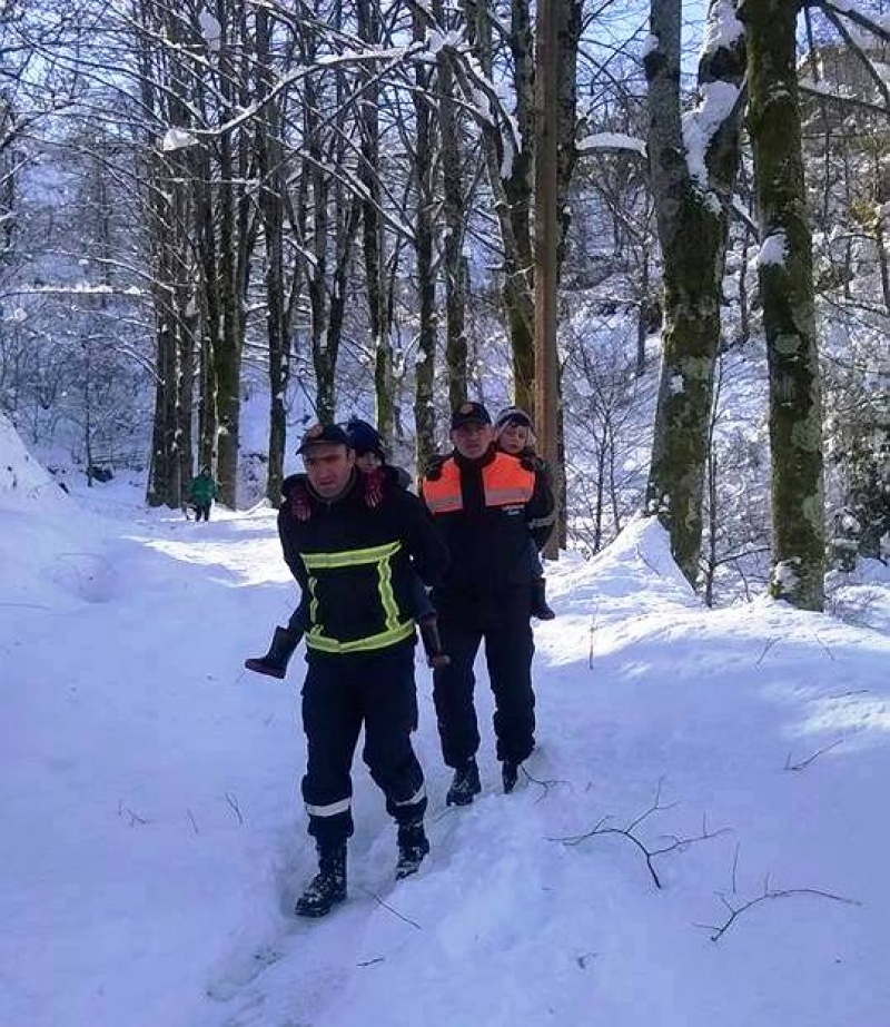 თოვლში ჩარჩენილი მანქანებიდან მაშველებს ბავშვები ზურგზე მოკიდებული გამოჰყავთ